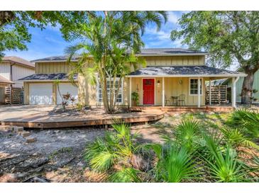 Charming two-story home with a well-maintained lawn, mature trees, front porch, and a two-car garage at 4063 Woodview Dr, Sarasota, FL 34232