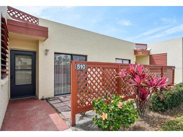 Charming condo featuring colorful foliage and decorative red lattice fencing around a private outdoor patio at 510 Spring Lakes Blvd, Bradenton, FL 34210