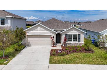 Inviting single-Gathering home featuring a two-car garage and a beautifully landscaped front yard at 5688 Woodland Sage Dr, Sarasota, FL 34238