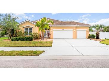 Beautiful one-story home featuring a well-manicured lawn, tiled roof, and a spacious driveway at 1189 Fraser Pine Blvd, Sarasota, FL 34240