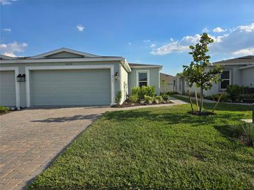 Charming single-story home with a well-manicured lawn, brick driveway and two car garage at 16120 Ivy Ridge Ct, Port Charlotte, FL 33953