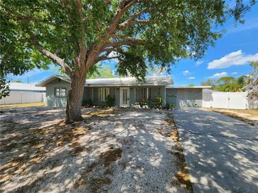 Charming single-story home with mature landscaping, a large tree, and a well-kept lawn at 2727 Waldemere St, Sarasota, FL 34239