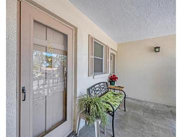 The front door is shown with charming bench seating and greenery at 2839 Swifton Dr # 28, Sarasota, FL 34231