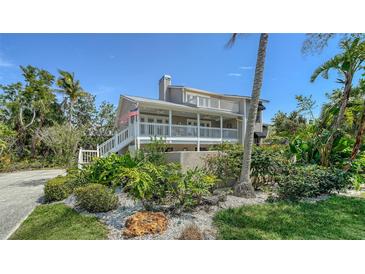 Charming two-story home featuring a spacious porch and lush landscaping with tropical accents at 3455 Flamingo Ave, Sarasota, FL 34242