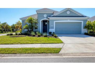 Charming single-story home featuring a well-manicured lawn, a two-car garage, and tasteful landscaping at 4107 Pine Meadow Dr, Parrish, FL 34219