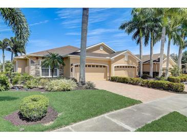 Stunning single-Gathering home with a three-car garage, paver driveway, lush landscaping, and soaring palm trees against a clear sky at 4250 Turnberry Cir, North Port, FL 34288
