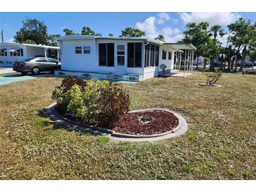 Charming single-story home featuring a screened porch, manicured lawn and landscaping at 5515 Denmark Dr, Bradenton, FL 34207