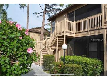 Charming condo with wood stairs, nice landscaping, and flowering bushes on a sunny day at 5767 Avista Dr # 5767, Sarasota, FL 34243