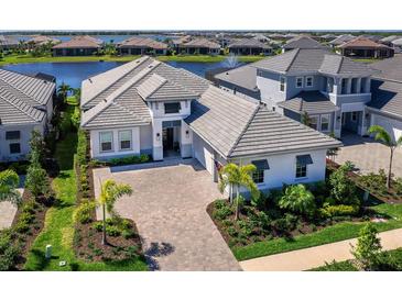 Beautiful single Gathering home with elegant architecture, manicured landscaping, and a brick driveway at 8335 Sea Glass Ct, Sarasota, FL 34240