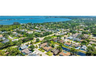 Stunning aerial view of a single-Gathering home in a lush community near the water, boasting a backyard pond at 914 82Nd Nw St, Bradenton, FL 34209