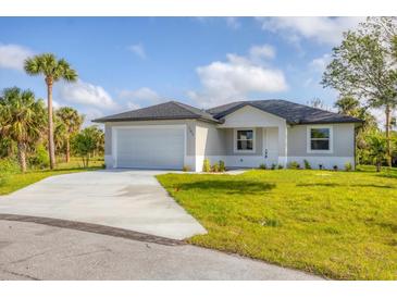 Charming single-story home featuring a two-car garage, well-manicured lawn, and welcoming curb appeal at 102 Arrow Ln, Rotonda West, FL 33947