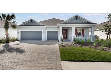 Charming single-story home featuring a two-car garage and a beautifully landscaped front yard at 1596 Laurel Brook Ln, Port Charlotte, FL 33953