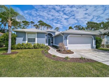 Charming single Gathering home featuring a well-manicured lawn, mature trees, and an attached two-car garage at 4146 Westbourne Cir, Sarasota, FL 34238