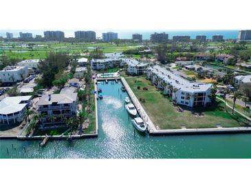Stunning aerial view of the community with boat docks, waterfront condos, and lush landscaping at 450 Gulf Of Mexico Dr # B207, Longboat Key, FL 34228