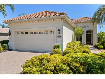 Charming home featuring a two-car garage, lush landscaping, and a beautifully tiled roof at 7159 Westhill Ct, Lakewood Ranch, FL 34202