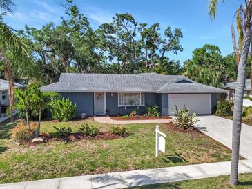 Charming single-story home with a well-manicured lawn, lush landscaping, and a welcoming walkway leading to the front door at 2933 Mayflower St, Sarasota, FL 34231