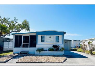 Charming mobile home featuring a screened-in porch, manicured landscaping, and a welcoming exterior at 3414 Spanish Oak Ter, Sarasota, FL 34237