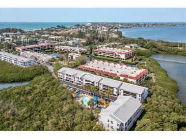Aerial view of complex showing community pool, landscaping, and Intracoastal at 3601 East Bay Dr # 205, Holmes Beach, FL 34217