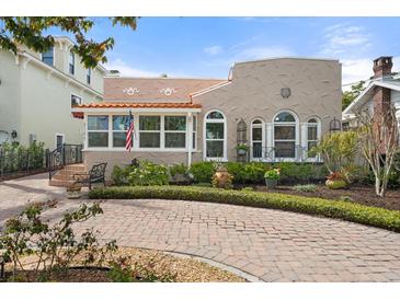Charming stucco home featuring a brick driveway, manicured landscaping, and an inviting front porch at 4109 Riverview Blvd, Bradenton, FL 34209
