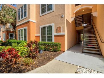 Exterior building view with colorful landscaping, stairs to the right, and window views to the residences inside at 4178 Central Sarasota Pkwy # 325, Sarasota, FL 34238
