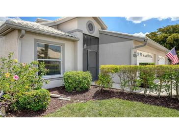 Charming single-story home with well-maintained landscaping, including green grass, bushes, and mulch at 4181 Brittany Ln # 25, Sarasota, FL 34233
