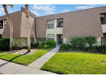 Charming condo with lush landscaping, a well-maintained lawn, and beautiful flowering shrubs at 4632 Ringwood Mdw # 28, Sarasota, FL 34235