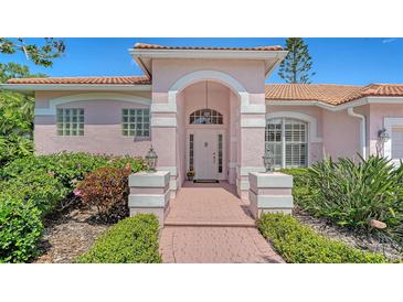 Charming pink home featuring a covered front entrance and beautifully landscaped garden at 5270 Far Oak Cir, Sarasota, FL 34238
