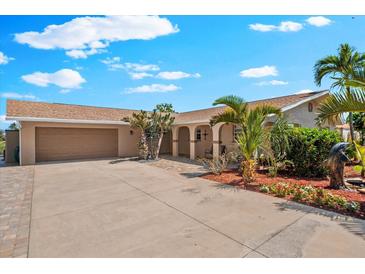 Charming single-story home featuring a wide driveway, lush landscaping and a two car garage at 5563 America Dr, Sarasota, FL 34231