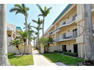 Beautiful condominium exterior with palm trees, lawn and walkways in a tropical paradise at 5963 Midnight Pass Rd # 355, Sarasota, FL 34242