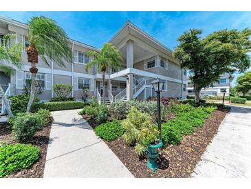 Beautiful condo building featuring mature landscaping, green lawns and a private entrance staircase at 628 Estuary Dr, Bradenton, FL 34209