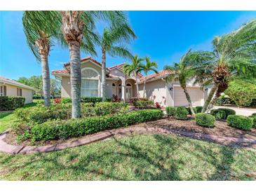 Charming home with well-manicured landscaping, lush green lawn and mature palm trees at 6324 41St E Ct, Sarasota, FL 34243