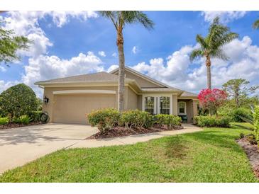 Charming single-story home featuring a two-car garage, lush landscaping, and well-maintained lawn at 7710 Seven Oaks Dr, Bradenton, FL 34201