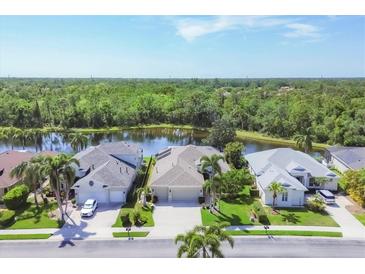 Gorgeous single Gathering home with lush landscaping, mature palm trees, and stunning water view at 7816 Ashley Cir, University Park, FL 34201