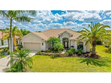 Inviting single-story home featuring a lush lawn, beautiful landscaping, and a two-car garage at 12822 Kite Dr, Bradenton, FL 34212