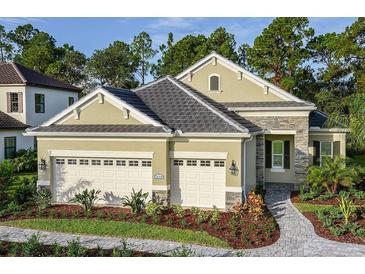 Charming single-Gathering home featuring a well-manicured lawn, stone accents, and a spacious two-car garage at 21221 Wacissa Dr, Venice, FL 34293