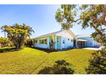 Charming single-story home with well-maintained lawn, mature trees, and a delightful, screened porch at 2703 Avenue B, Holmes Beach, FL 34217