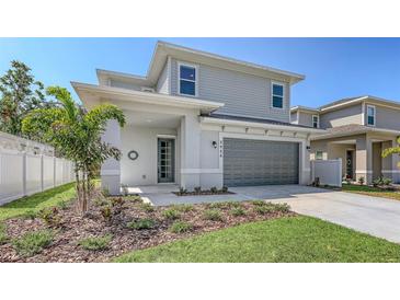 Charming two-story home with grey siding, a two-car garage, and a well-manicured lawn at 2926 River Run Way, Bradenton, FL 34208