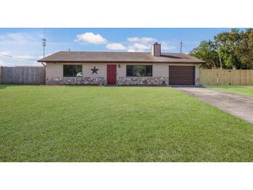 Charming single-story home featuring a well-maintained lawn, stone accents, and a red front door at 3123 40Th W Ave, Bradenton, FL 34205