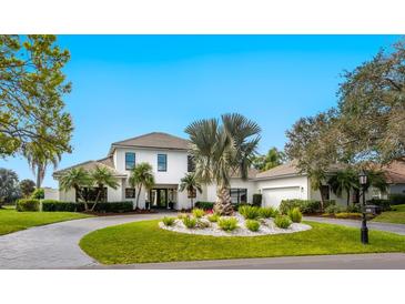 Stunning two-story white home with well-manicured front yard and circular driveway at 4104 Las Palmas Way, Sarasota, FL 34238
