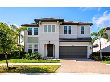 Two-story home boasts a two-car garage, tiled roof, well-maintained lawn, and professional landscaping at 4881 Antrim Dr, Sarasota, FL 34240