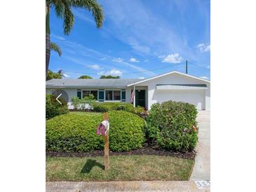 Charming single-story home with a manicured front yard, colorful landscaping, and a welcoming mailbox at 5523 Scotia Pl, Sarasota, FL 34231