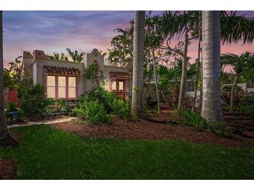 Charming home featuring a stucco exterior, red tile roof, and lush landscaping at 107 Nippino W Trl, Nokomis, FL 34275