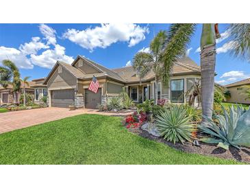 Beautiful home exterior featuring a lush landscaped yard, tile roof and a two-car garage at 11176 Roseate Ct, Sarasota, FL 34238