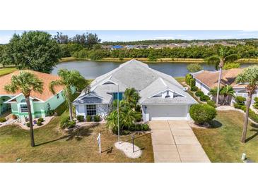 Beautifully landscaped single-Gathering home with a charming front yard and stunning waterfront view at 2435 E Del Webb Blvd, Sun City Center, FL 33573