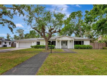 Charming home with mature trees, a well-manicured lawn, and a classic white facade at 320 25Th W St, Bradenton, FL 34205