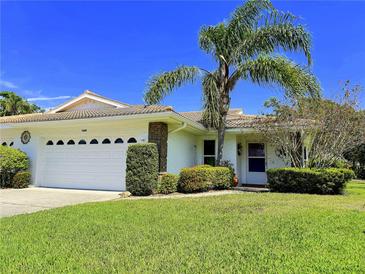 Charming single-story home with manicured lawn, mature landscaping, and a spacious two-car garage at 5711 Garden Lakes Palm, Bradenton, FL 34203