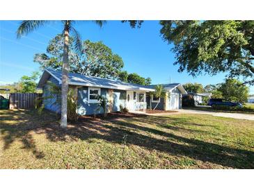 Charming single-story home featuring a well-manicured front yard and an attached garage with tropical landscaping at 8731 Peggy Ave, Sarasota, FL 34231