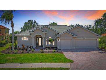 Charming one-story home features a well-manicured lawn, beautiful landscaping, and a three-car garage at 12628 Daisy Pl, Bradenton, FL 34212