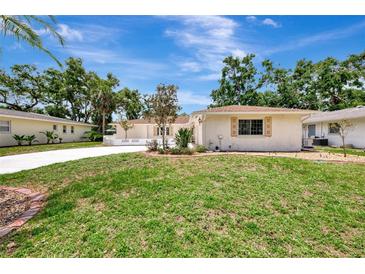 Charming single-story home with well-manicured lawn and lush landscaping on a sunny day at 2924 Valley Forge St, Sarasota, FL 34231