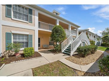 Inviting exterior view with manicured landscaping and white stairs leading to the second floor units at 4210 Caddie E Dr # 201, Bradenton, FL 34203